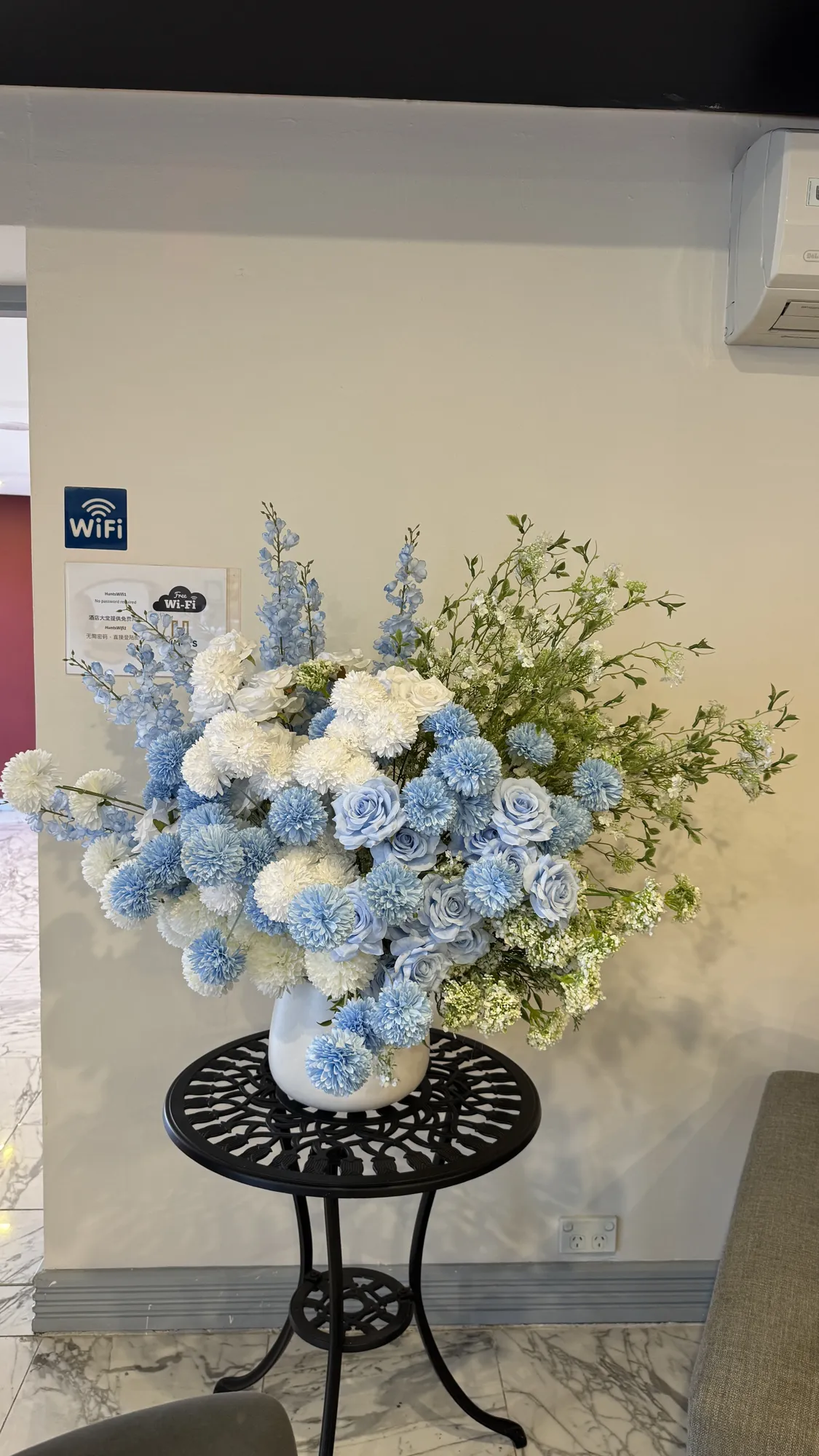 Blue and white floral arrangement on a black side table